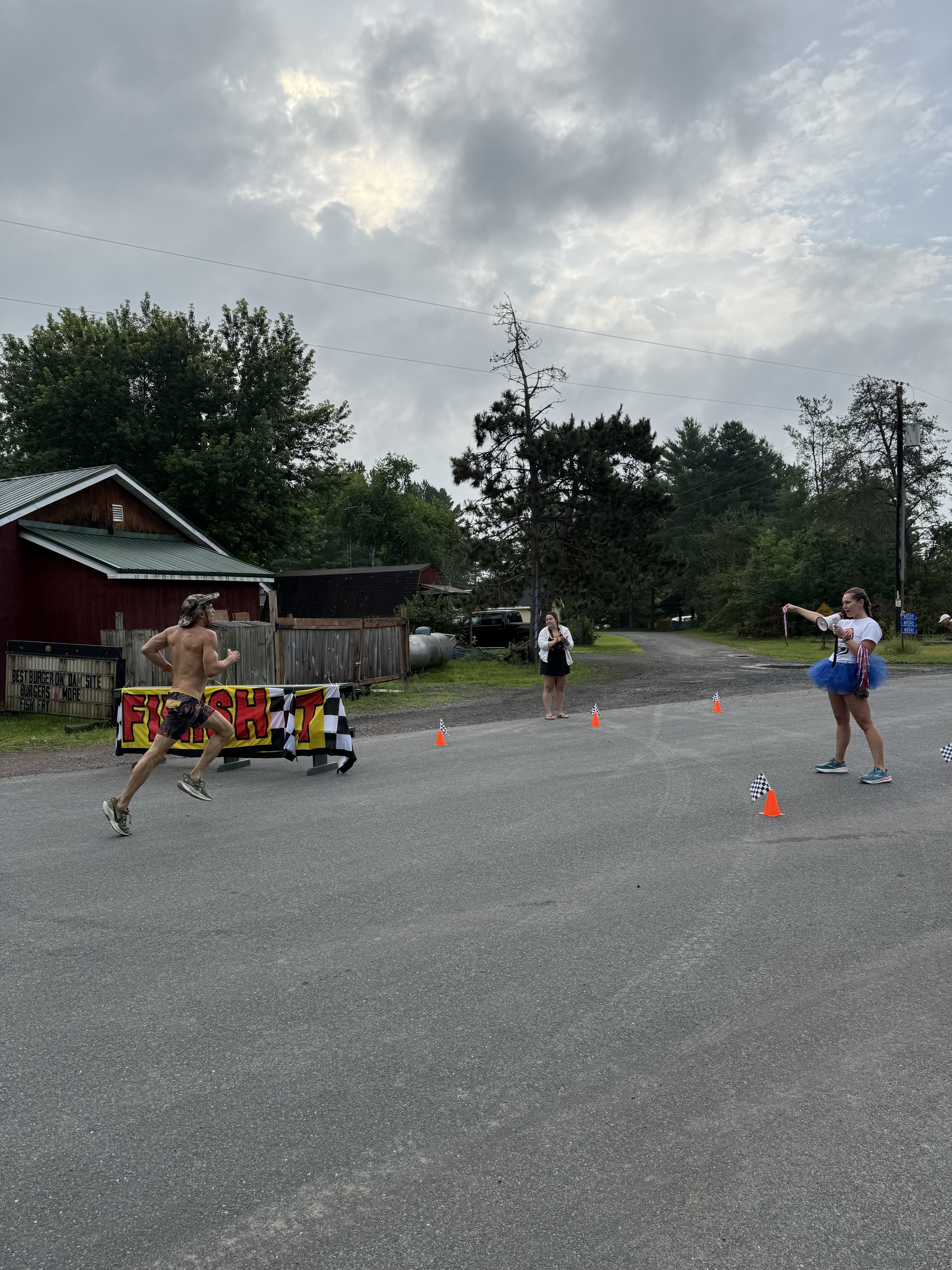 Runners crossing the finish line banner with cones marking the course